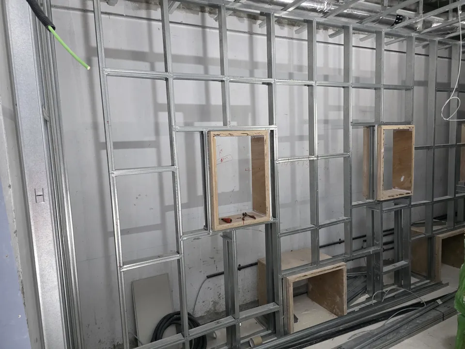 Steel-stud wall framing with timber boxes for the in-wall speakers