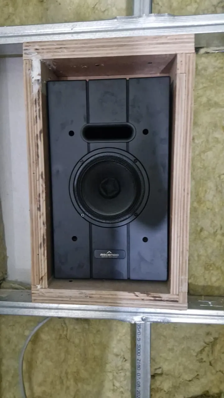 A speaker mounted in its own insulated box inside the wall