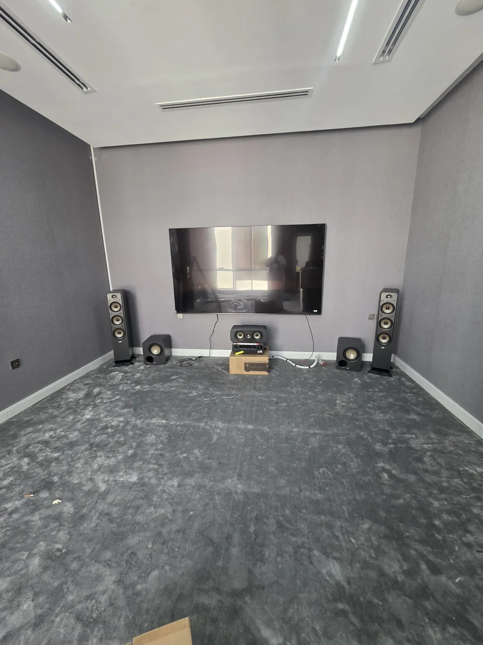 The room before the treatment: speakers placed around the TV wall, walls still bare