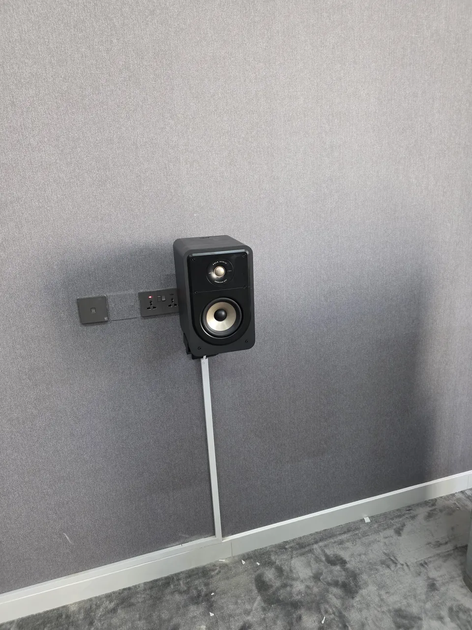 A wall-mounted surround speaker